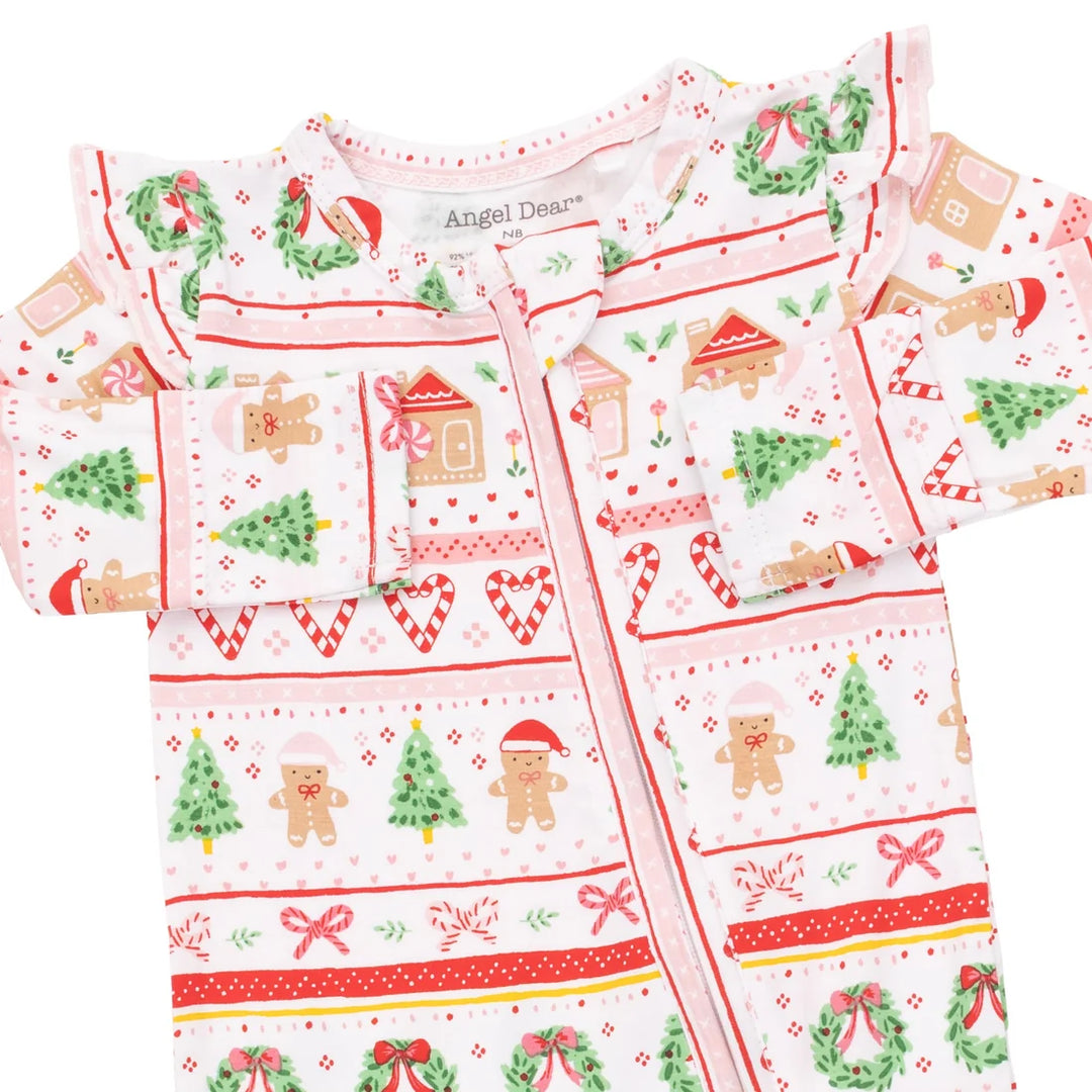 A baby zip-up sleeper or onesie with a festive Christmas print, featuring gingerbread men, trees, wreaths, and candy canes on a white background. The brand name 'Angel Dream' is visible on the inner neck label.