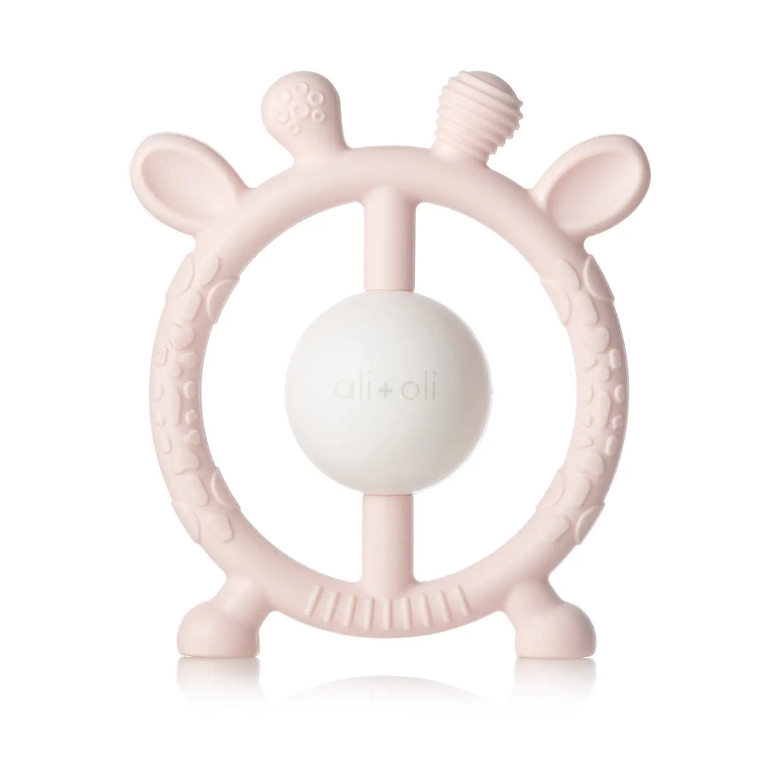 Pink baby teething ring with a white ball on a white background