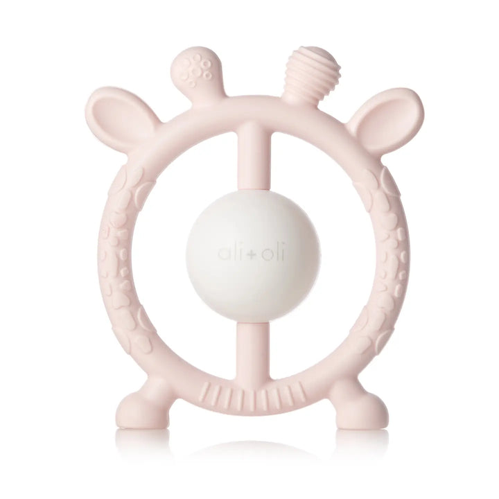 Pink baby teething ring with a white ball on a white background