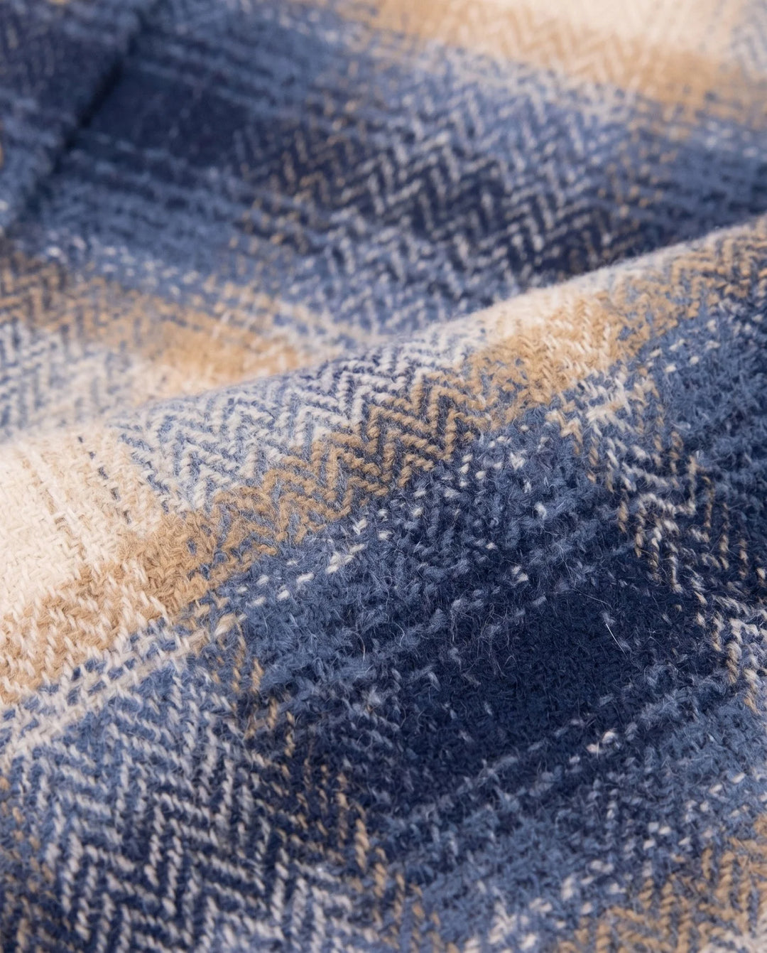 close up of the textured fabric in colors in the shirt: navy, beige and tan