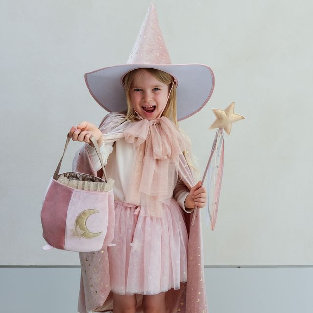 Child in a pink witch costume with a wide-brimmed hat, cape, and star wand.