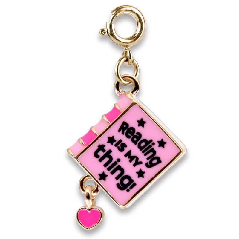 pink book on a charm. attached to a gold clasp. the book says "reading is my thing"