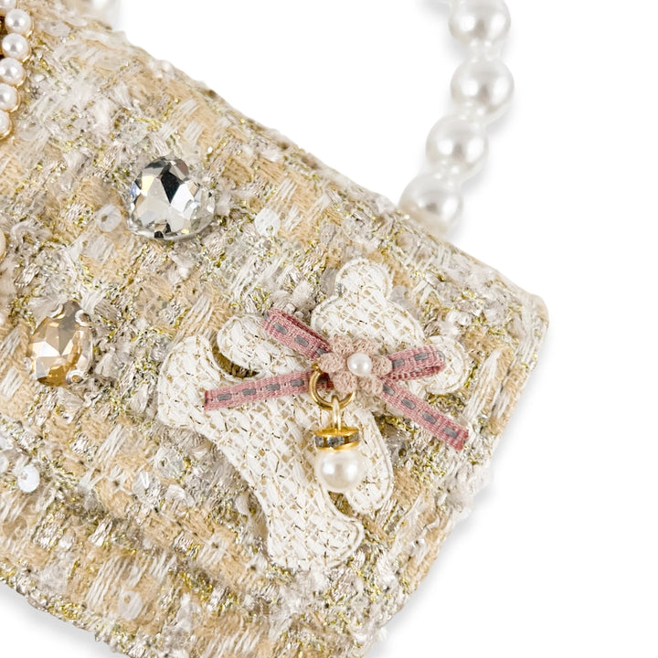 Decorative phone case with pearls, crystals, and a bow on a white background