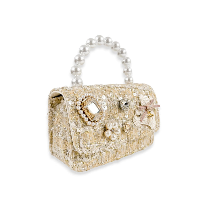 Gold glittery handbag with pearl handle and embellishments on a white background