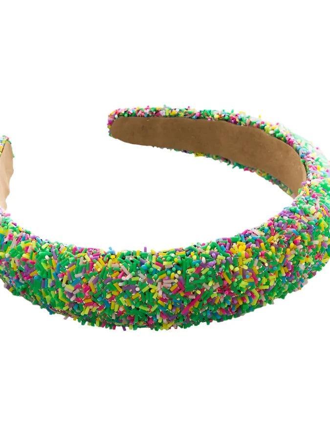 multi colored rubber sprinkles cover this chunky girls headband. Green is the dominant color.