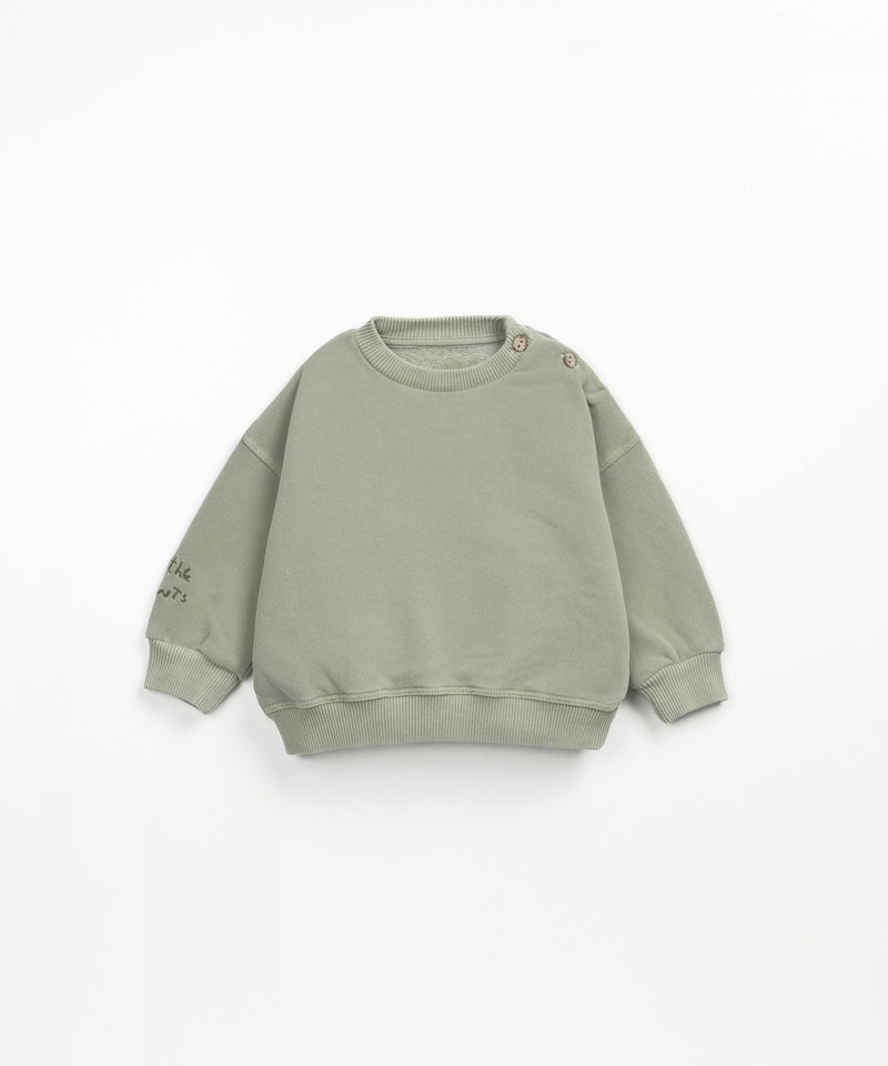 green crewneck sweatshirt with drop shoulder and two buttons at the neck