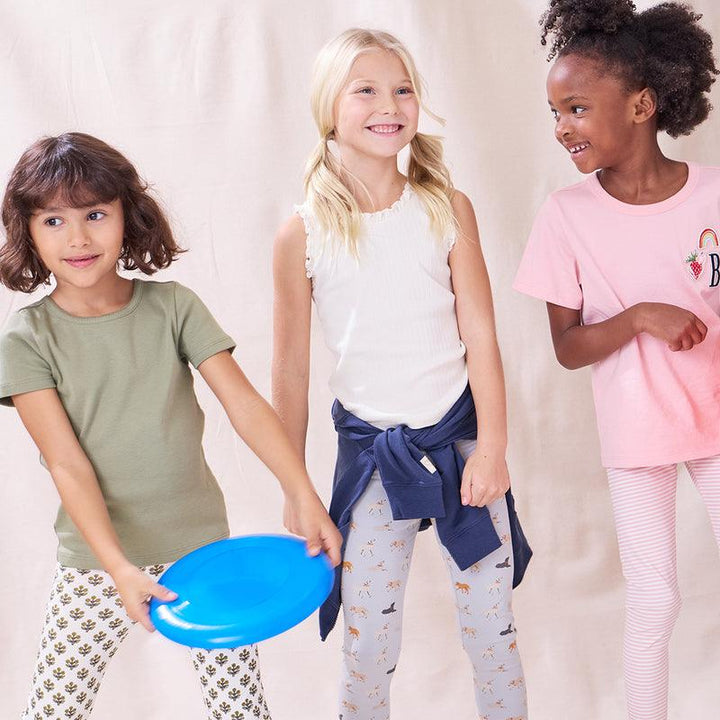 girls modeling different cotton basics, one of them being the ivory ribbed tank with ruffled trim. 
