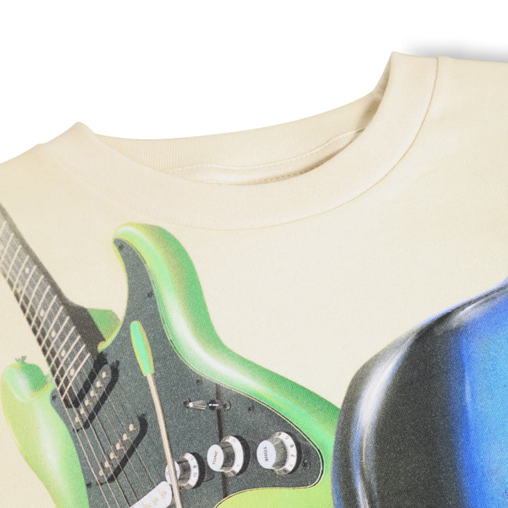 Close-up of a t-shirt with a graphic of a green electric guitar on a beige background