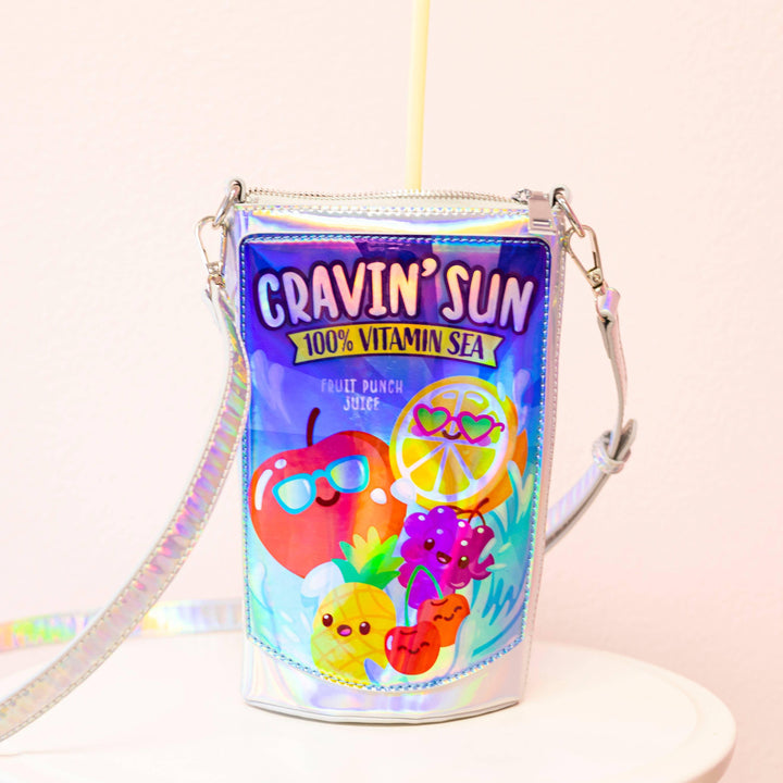 close up of the handbag with the straps attached. the bag looks like a capri sun juice box. 
