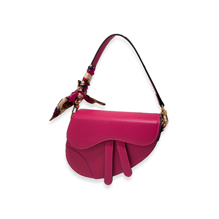 fuschia color purse having a saddle shape with shoulder strap. 