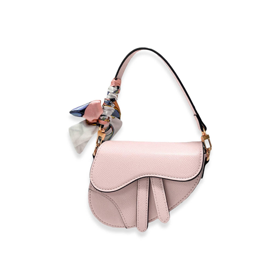 saddle purse in a light pink color with scarf attached to the shoulder strap