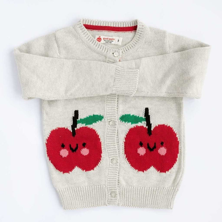 Children's sweater with red apple designs on a white background