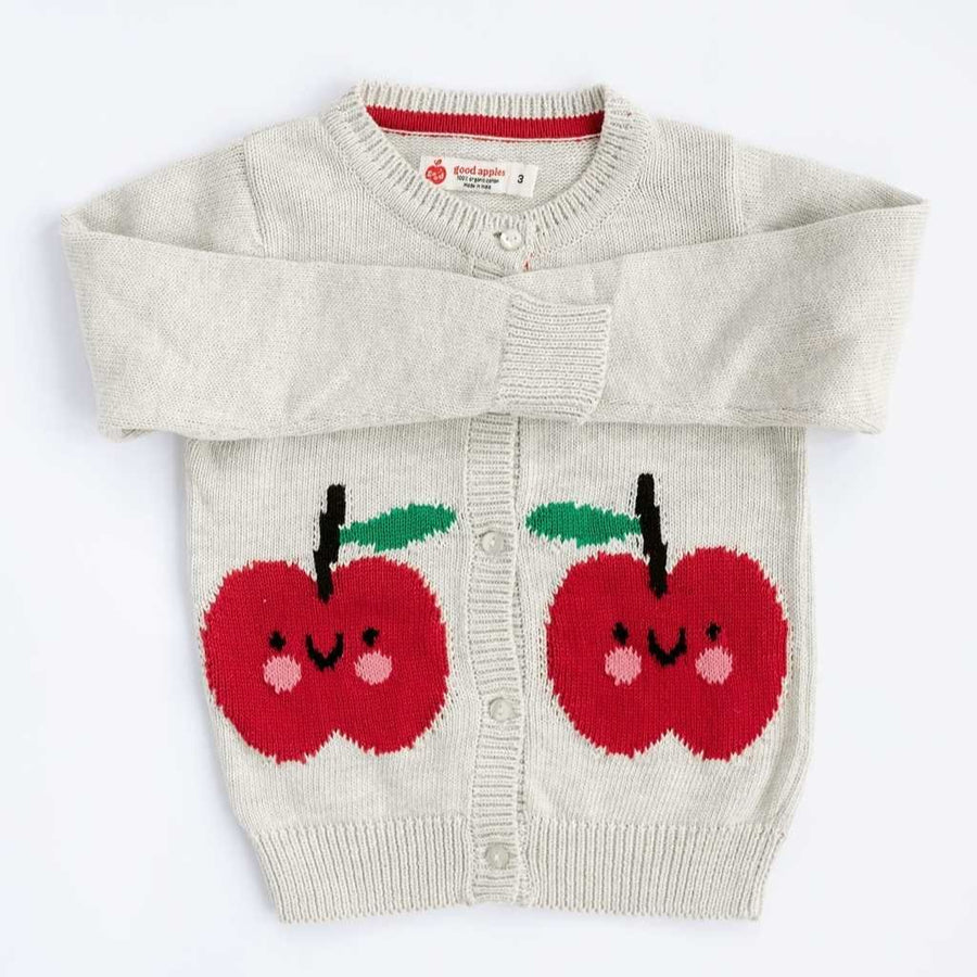 Children's sweater with red apple designs on a white background