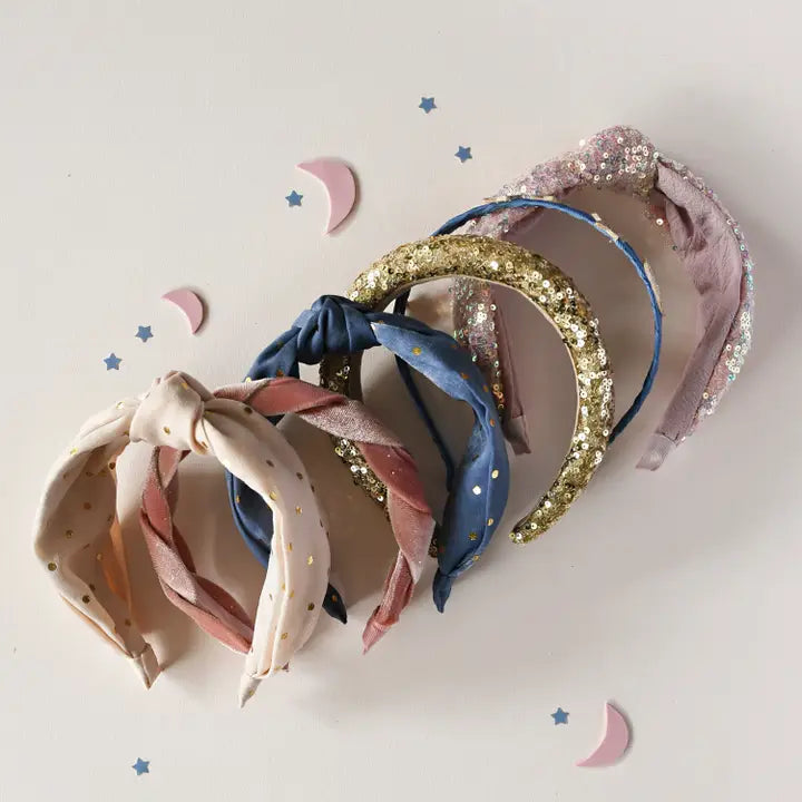 a grouping of all the headbands in the collection. polka dot, blue knot, gold sequin, pink sequin knotted