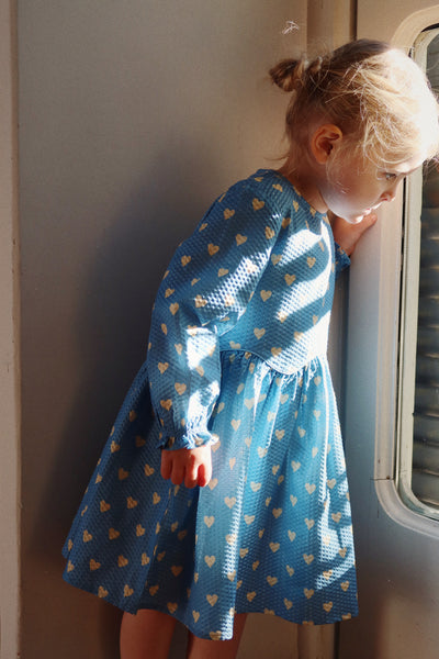 this image shows the little girl looking out the window and how the dress hits at the knee