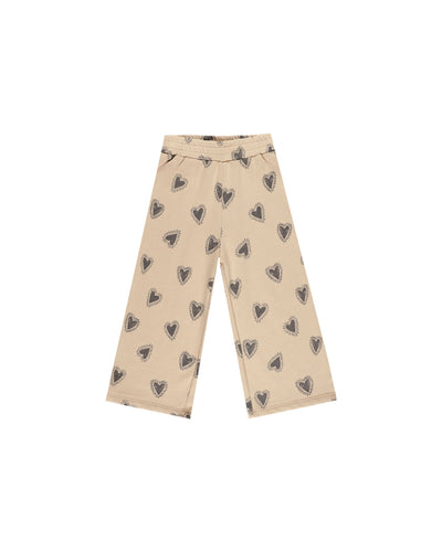 wide leg sweatpants in a beige color with gray/navy hearts all over. elastic waist. 