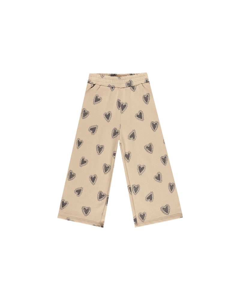 wide leg sweatpants in a beige color with gray/navy hearts all over. elastic waist. 