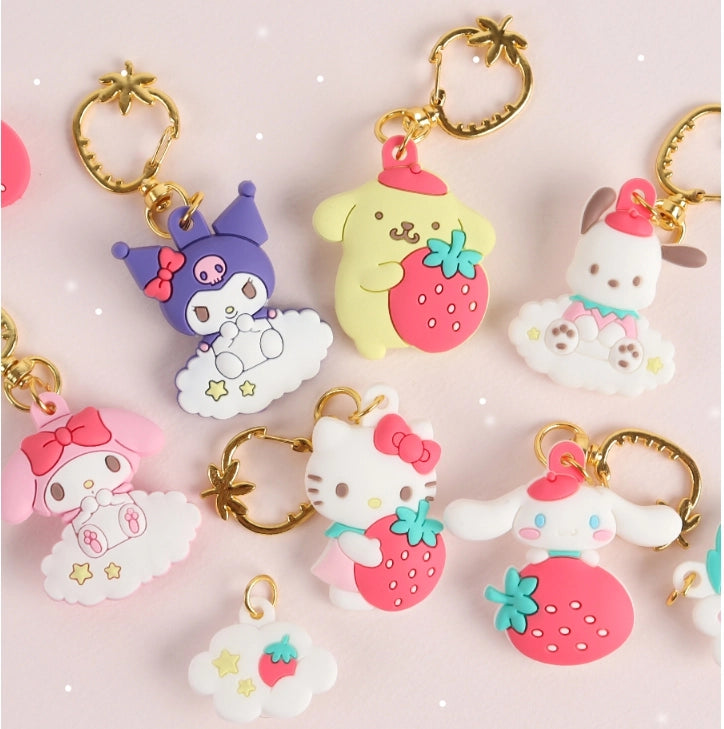 Collection of colorful keychains with cartoon characters on a pink background