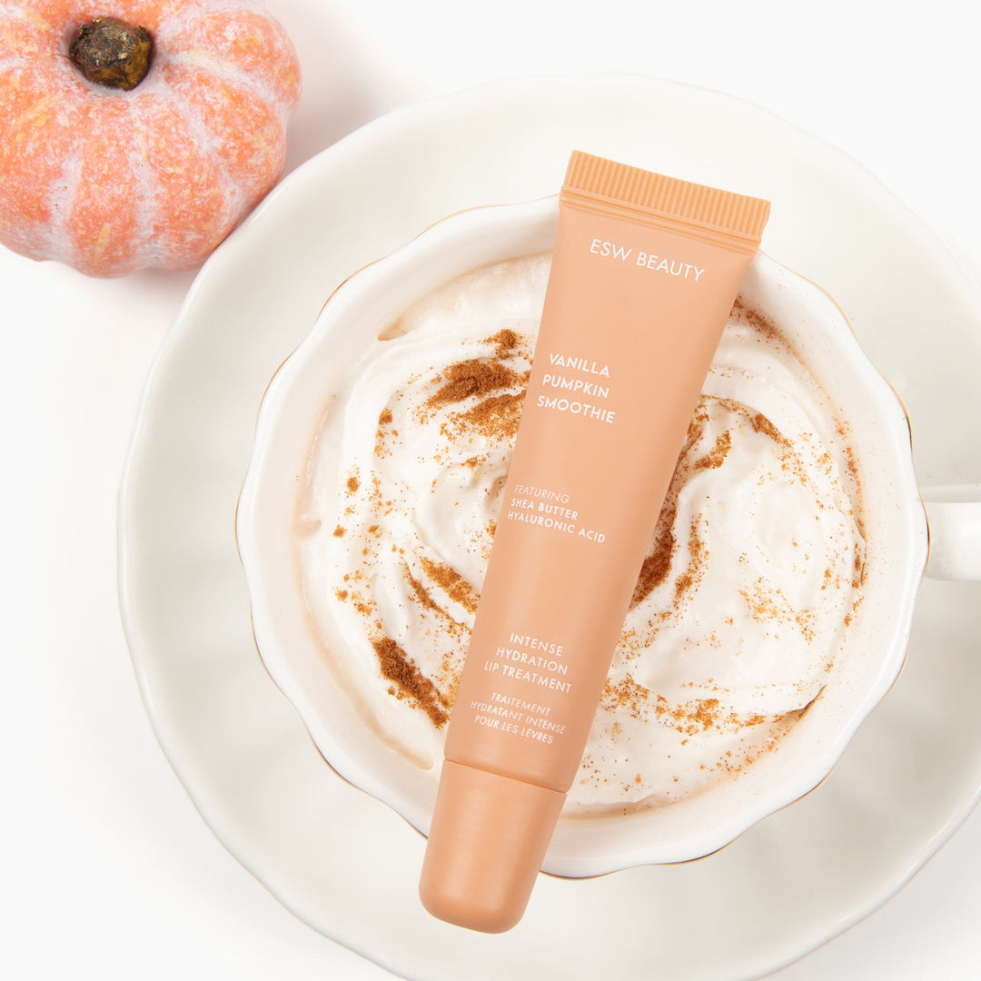 Cosmetic tube labeled 'ESW Beauty' on a cup of vanilla latte with pumpkin spice.