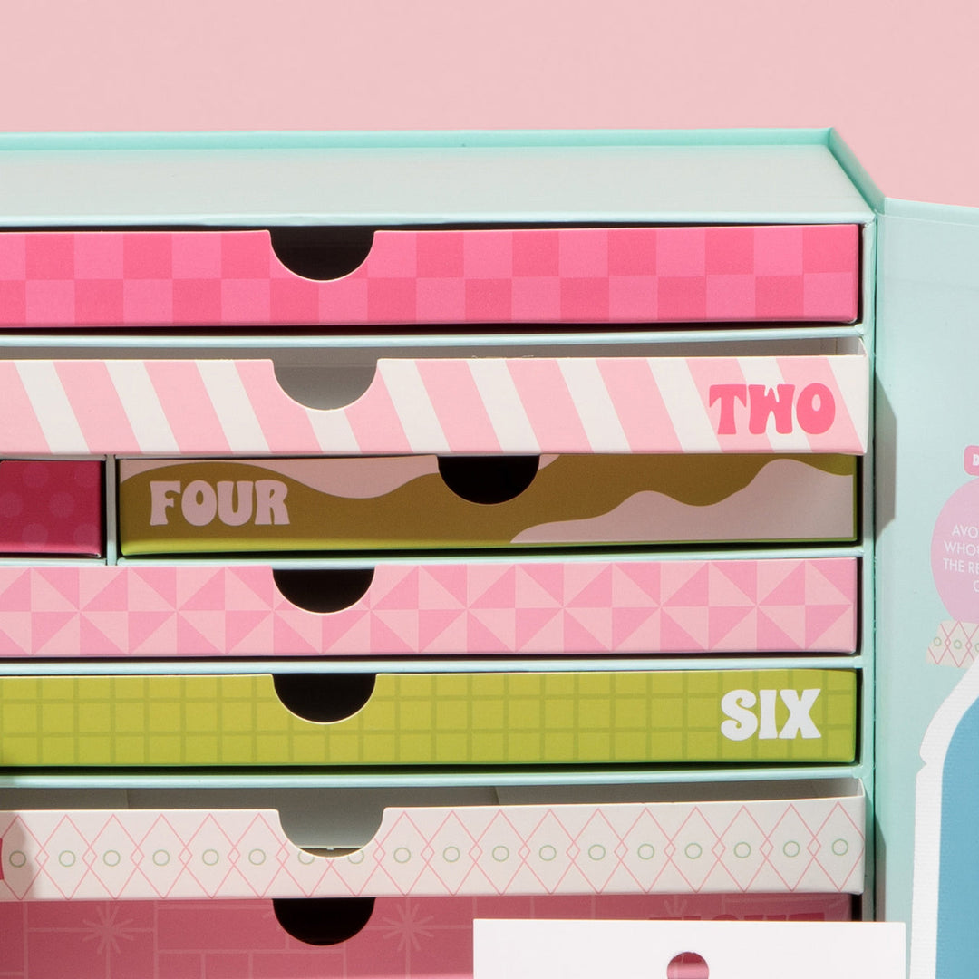 Set of colorful drawers with geometric patterns and labeled sections on a pink background