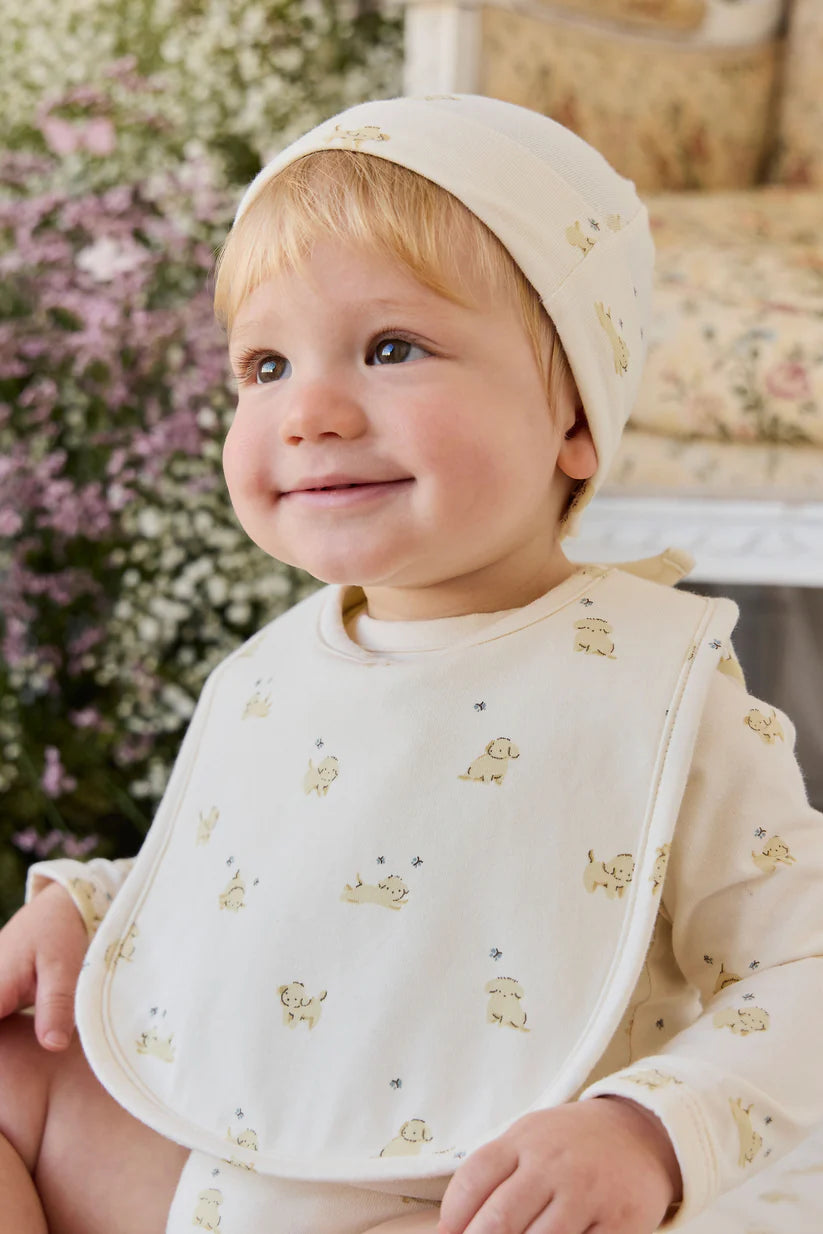 Baby wearing a puppy outfit with a floral background