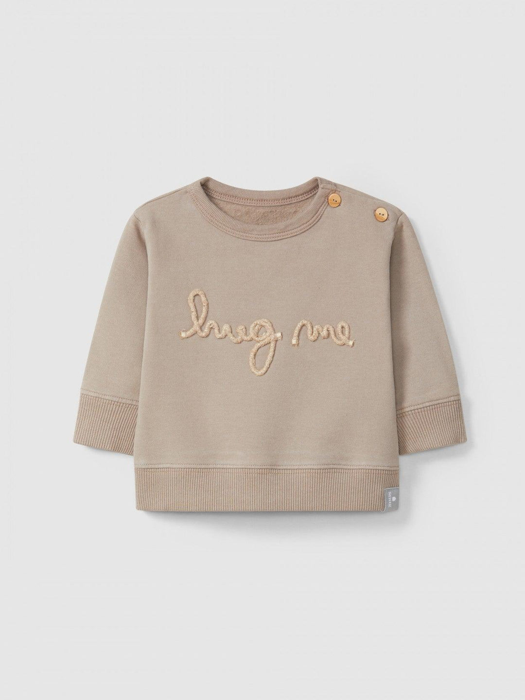 taupe sweater that reads"hug me" in light pink embroidery. two buttons on the top for easy changing. 