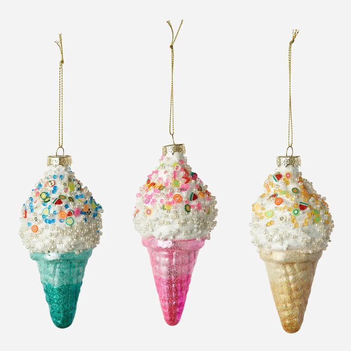 Three ice cream cone ornaments hanging side by side on a light gray background. Each ornament has a white textured scoop topped with colorful sprinkles and a glittery cone in teal, pink, and gold.