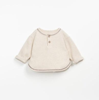 beige sweater with brown stitching and two buttons at the top