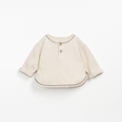 beige sweater with brown stitching and two buttons at the top