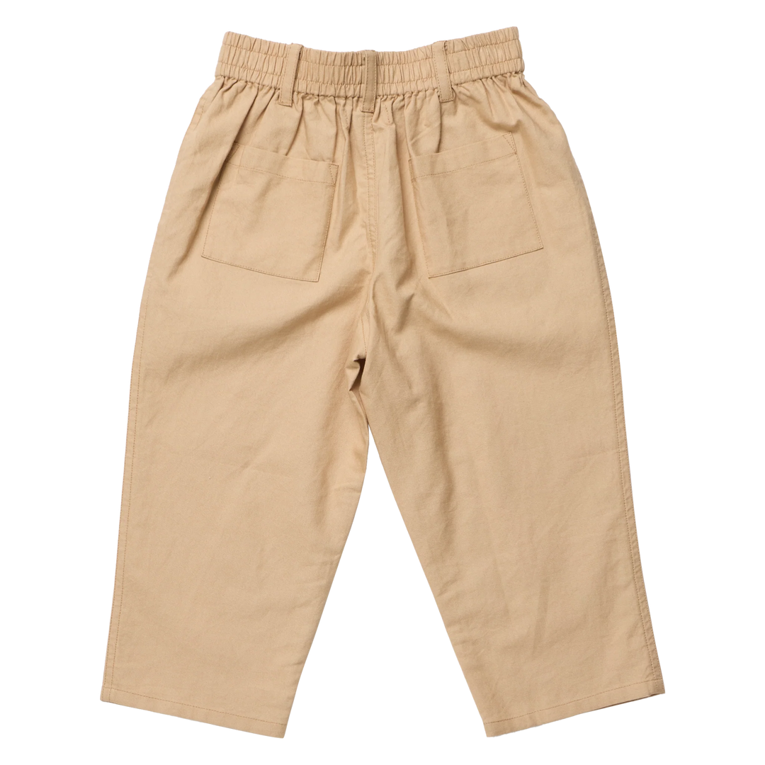 A pair of beige cotton trousers with an elastic waistband, pleated front, and two large patch pockets on the back, shown flat on a white background.