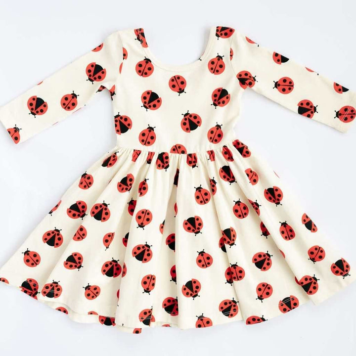 White dress with red ladybug pattern on a white background