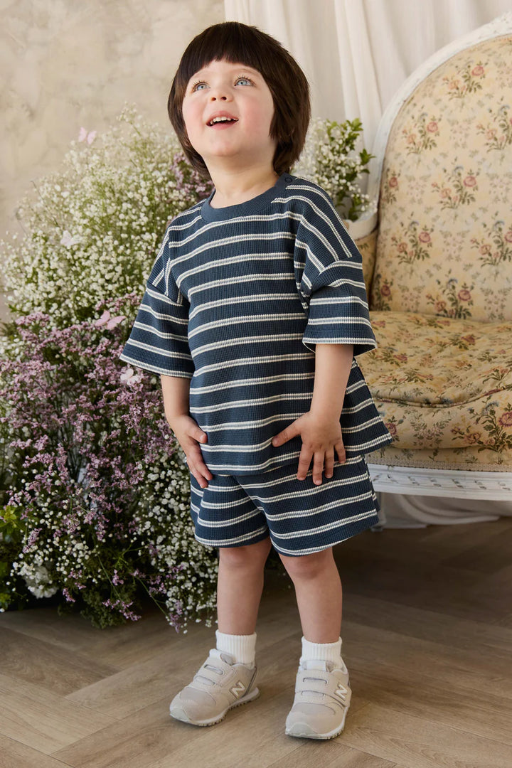 little boy wearing a navy striped waffle short sleeve shirt and shorts