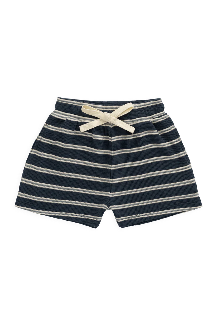 A pair of children's shorts with horizontal navy blue and cream stripes, featuring an elastic waistband and a matching cream bow, shown against a plain white background.