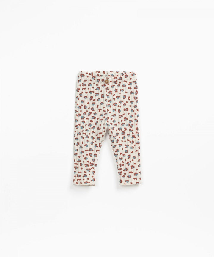baby pants in beige colorway with leopard print the spots have blue and rust colors in them. 