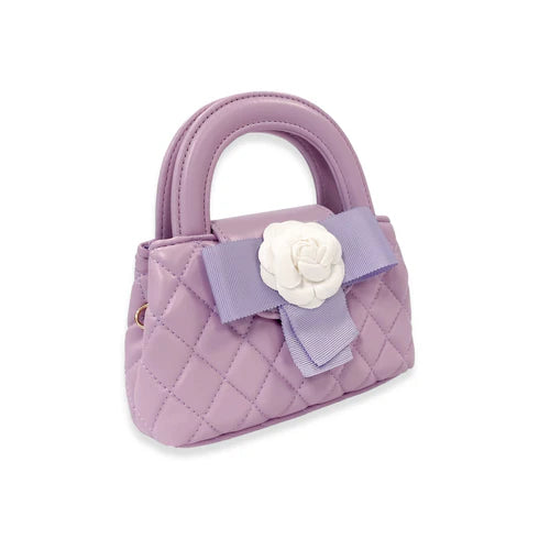 Purple quilted handbag with a white flower and bow on a white background