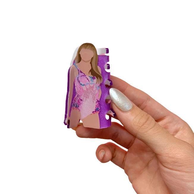 claw clip, in the shape of Taylor Swift . Her hair is down in her outfit associated with her Lover Era