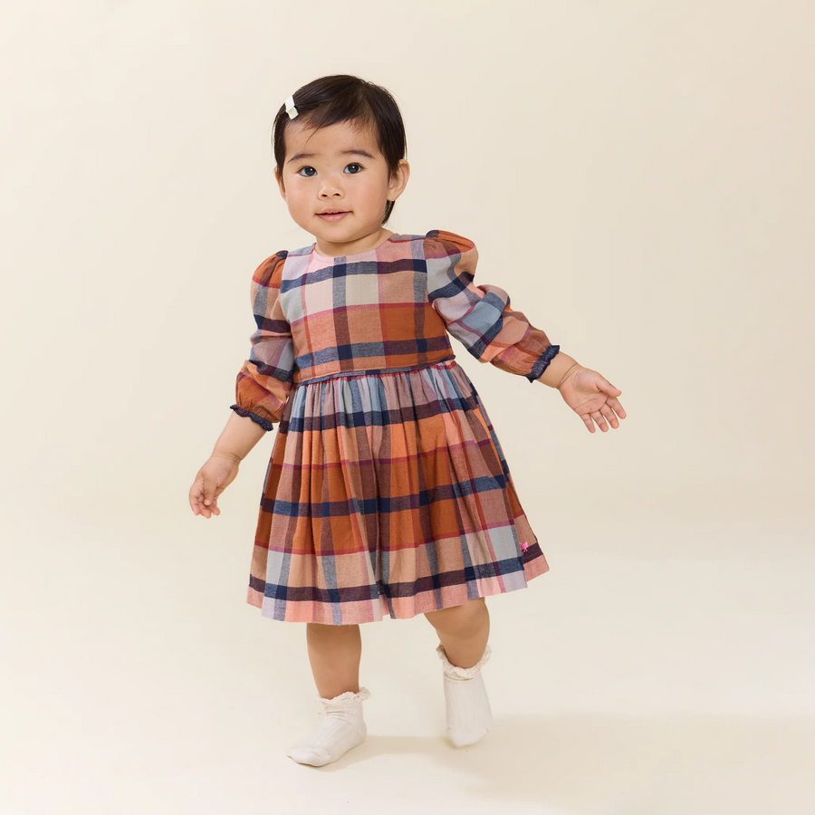 little girl wearing the mae dress in rust plaid. the dress hits right above the knee. 