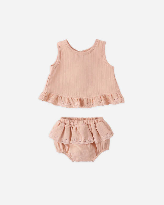Pink baby outfit with top and bloomers on a white background