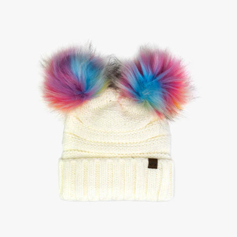 ivory beanie with two pom poms on top. The poms are rainbow colored and appear like fur. 