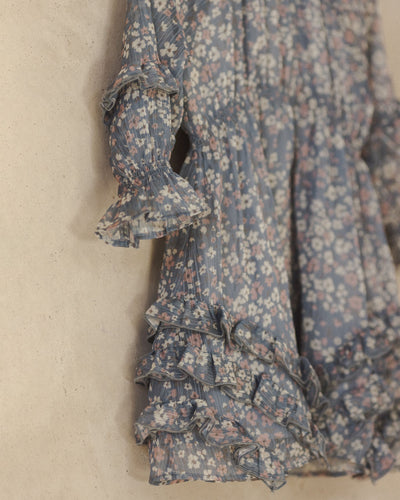 close up of the material of the dress, chiffon look, delicate florals and ruffle at sleeve and the bottom of the dress