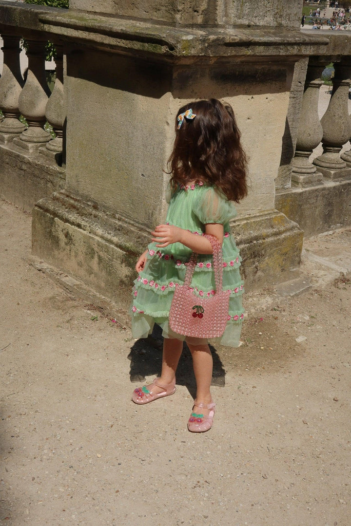 little girl wearing the green tulle dress and standing up straight so you can see the length of the dress and where it hits just above the knee.