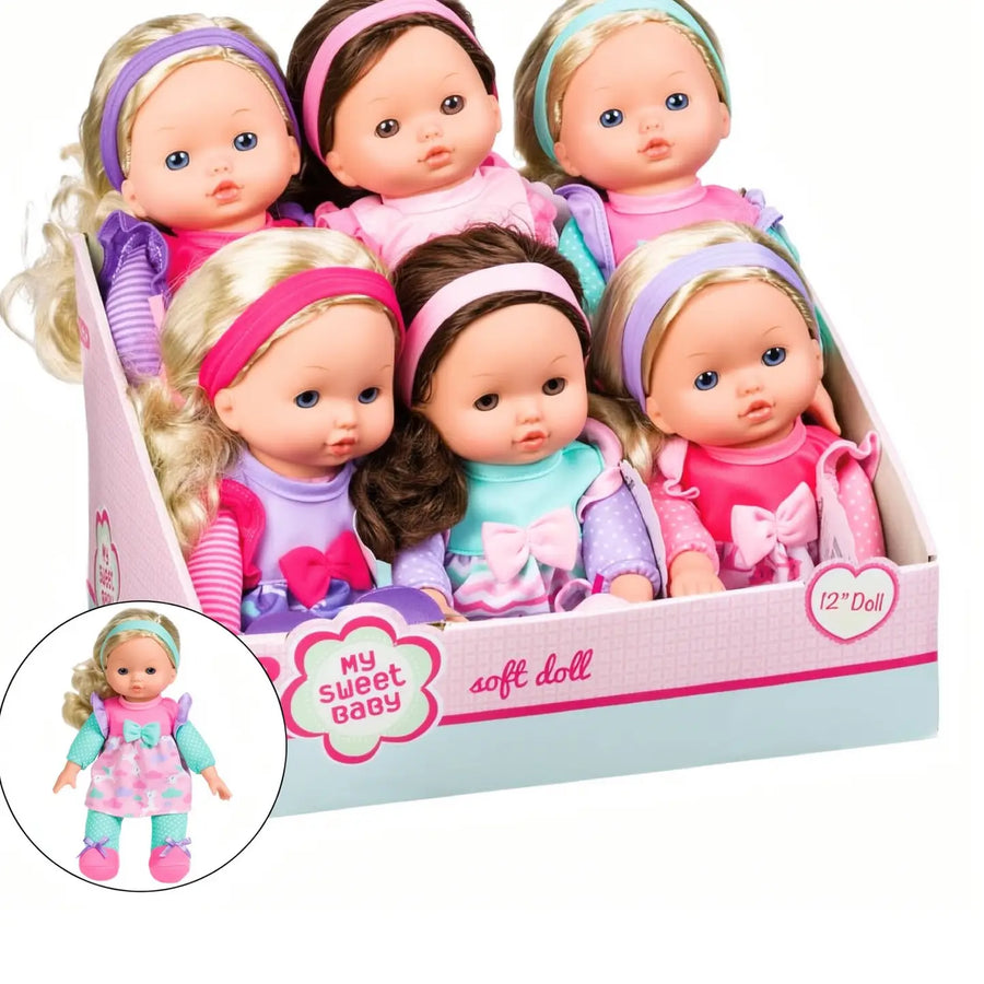 A boxed set of six soft dolls in pastel clothing and colorful headbands, displayed in a pink and light blue retail box. A circular inset shows one doll wearing a pink dress.