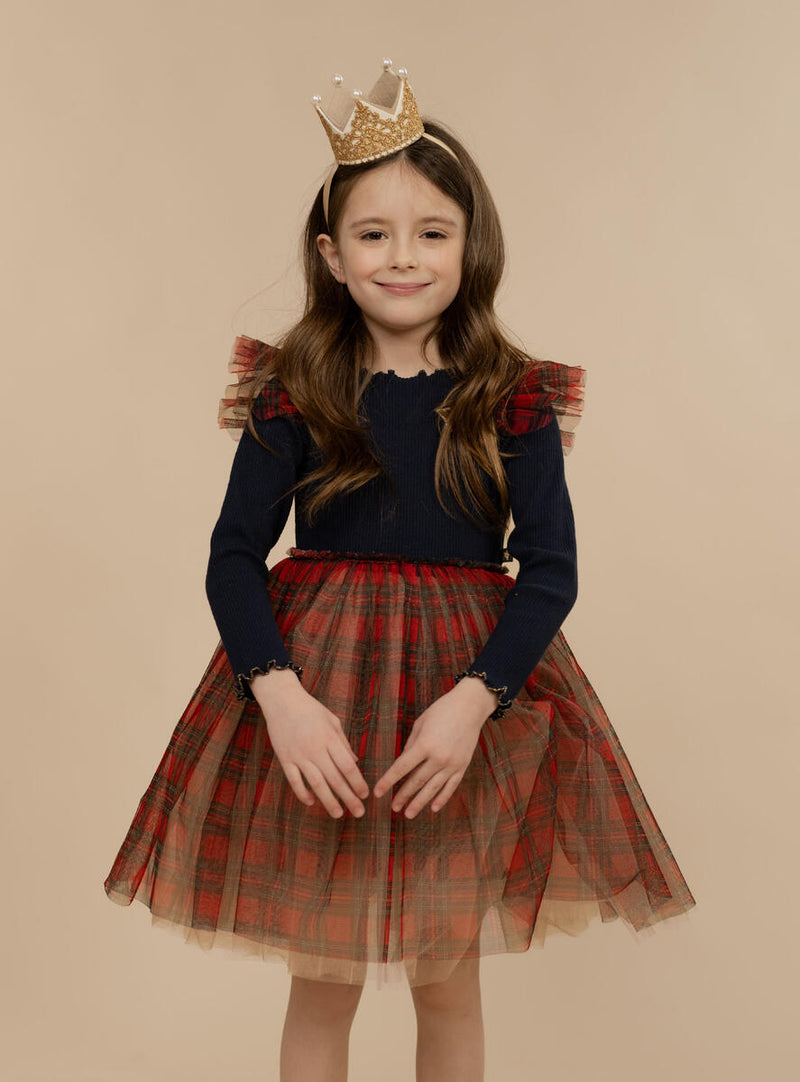 little girl modeling the navy top on the dress with red plaid bottom. 