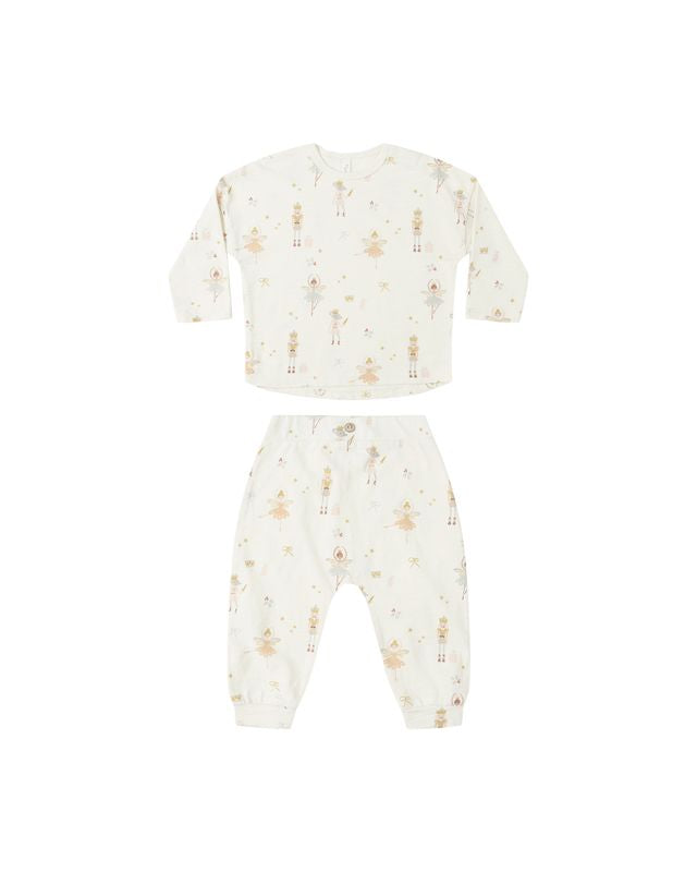 Baby outfit with long-sleeve top and pants with a nutcracker print on a white background
