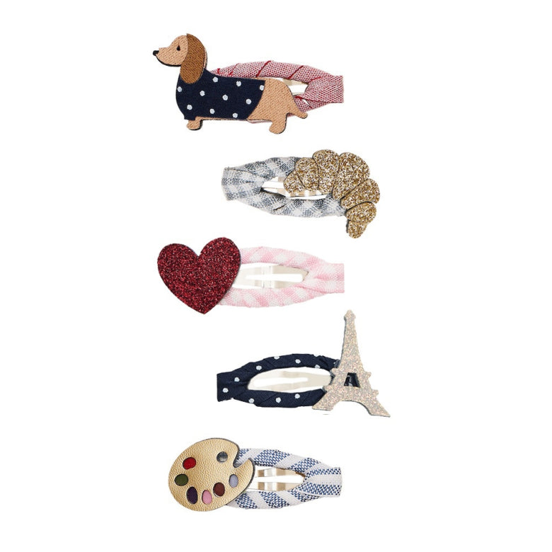 Set of decorative hair clips including a dog, heart, Eiffel Tower, and paint palette design on a white background.