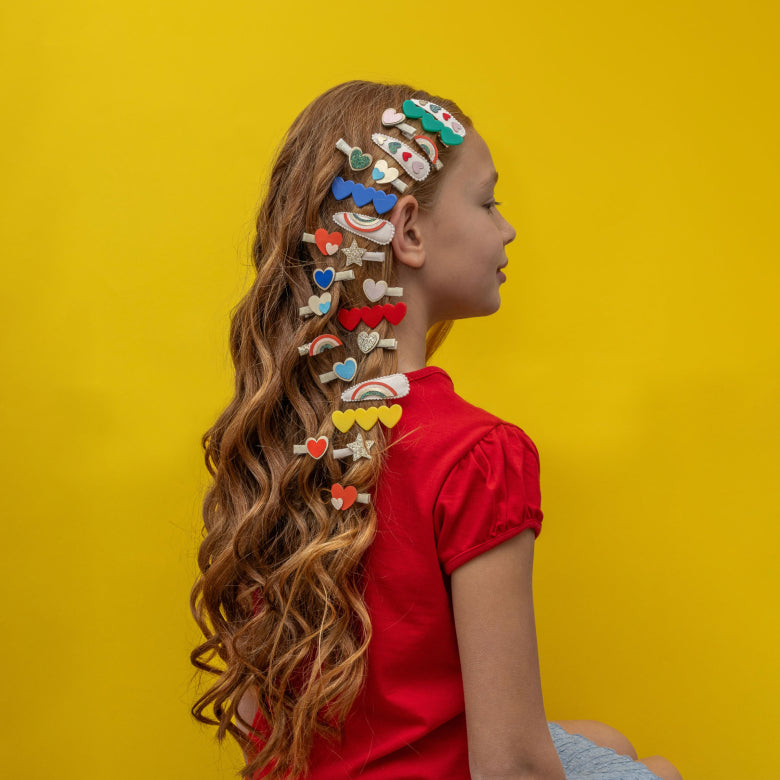 Girl with colorful hair accessories on a yellow background