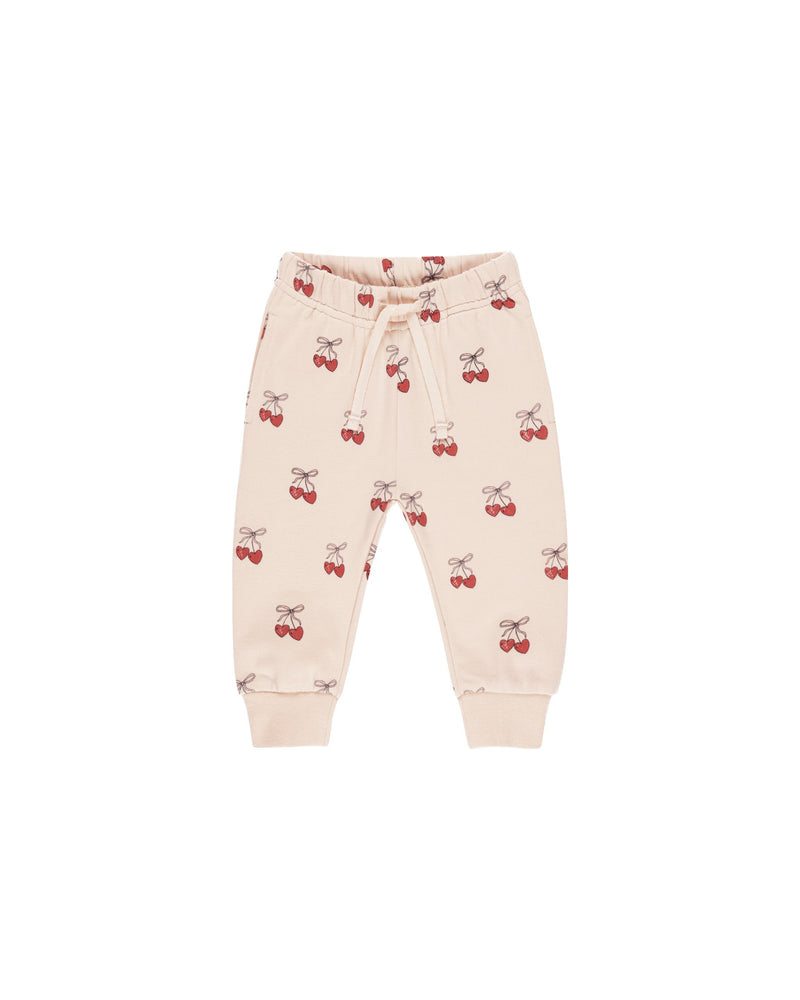 beige pink sweapants with cherries all over the pants 