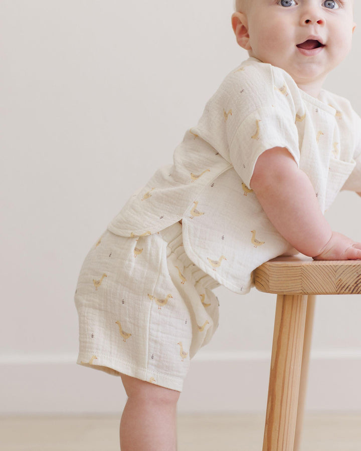 this picture shows the top and bottom with the geese on it. the top has the bottom od the top with a rounded edge and the elastic waist at the shorts. 