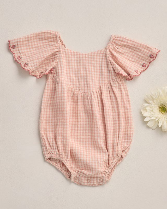 Pink checkered baby romper with ruffled sleeves on a light gray background