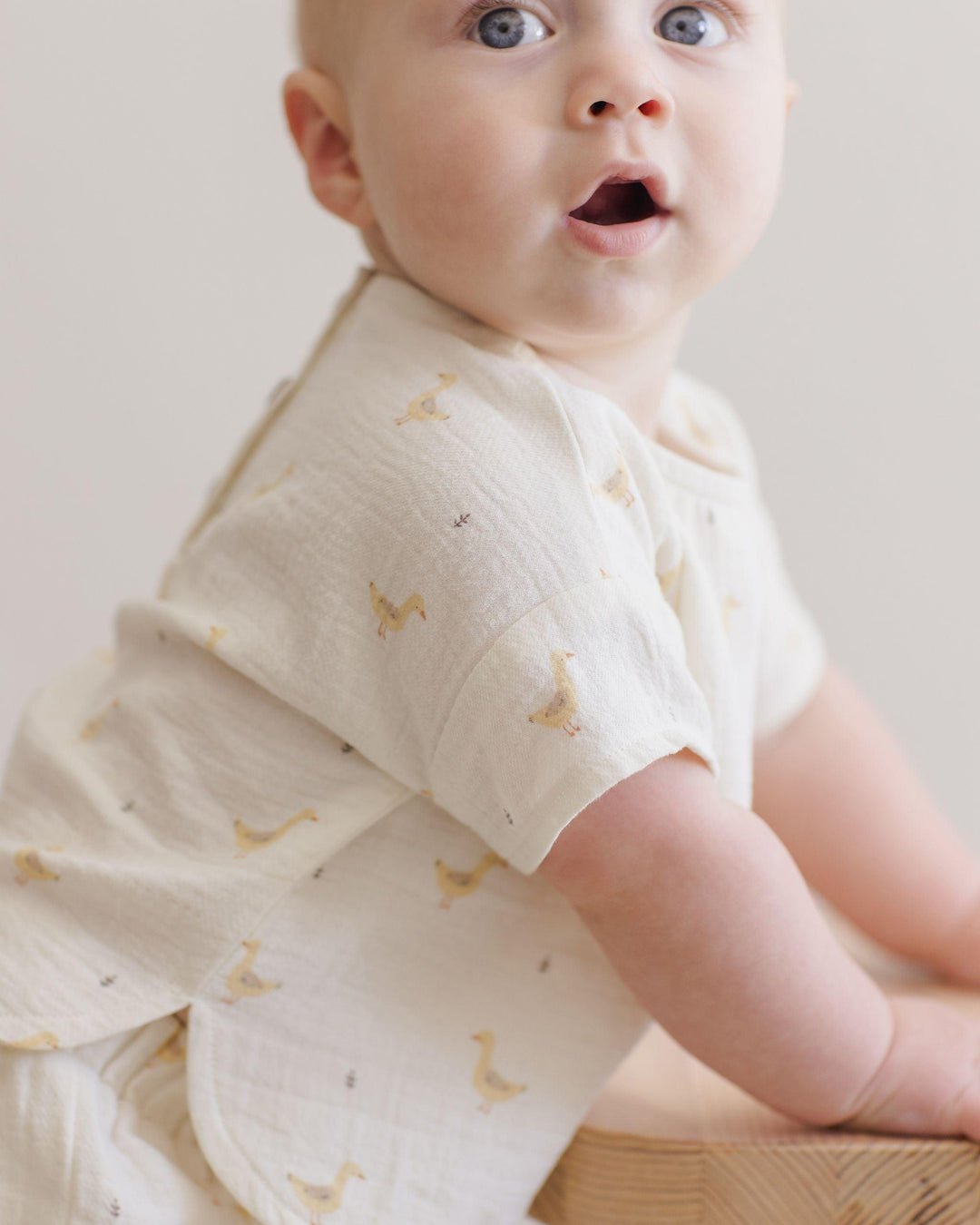 baby modeling the woven set with geese on it. this picture shows the sleeve hits the baby at the elbow basically. 